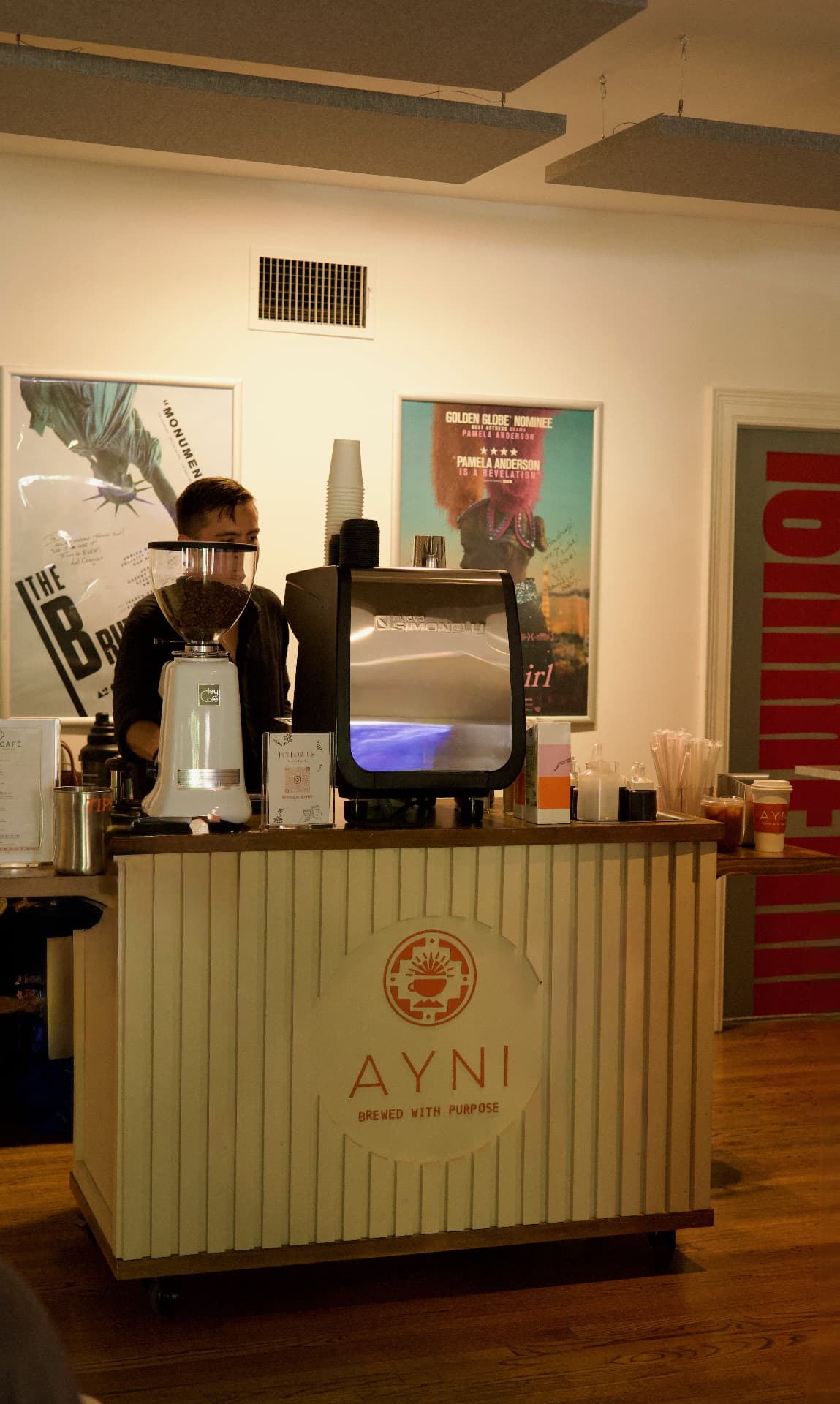 The Ayni Café cart set up indoors with a barista preparing drinks